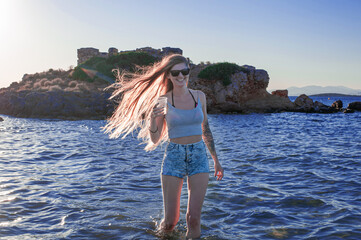 young slander happy woman in short summer cropped top and small shorts by the sea