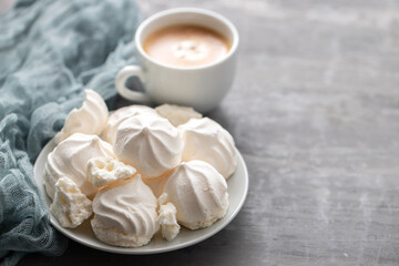 Obraz na płótnie Canvas cup of coffee with meringues on white dish