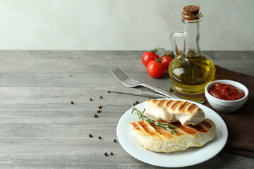 Concept of tasty eating with grilled chicken meat on gray textured table