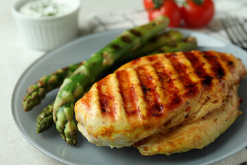 Concept of tasty eating with grilled chicken meat on white textured table