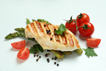 Grilled chicken meat, asparagus and ingredients on white background