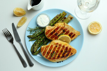 Concept of tasty lunch with grilled chicken and asparagus on white background