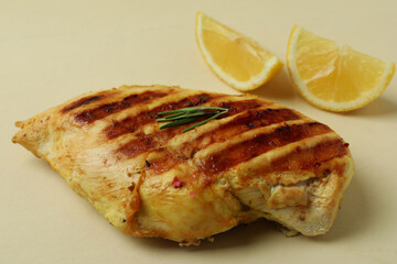 Grilled chicken meat and lemon on beige background