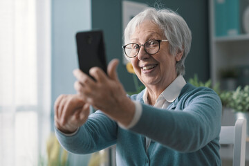 Senior woman taking selfies with her smartphone