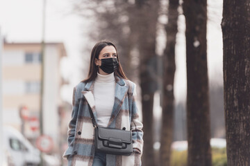 Woman with face mask walking outdoors