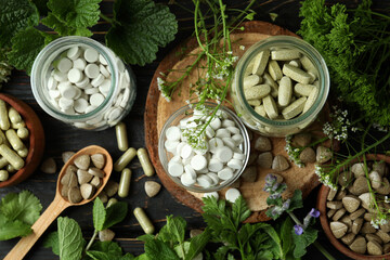 Concept of herbal medicine pills on wooden table, top view