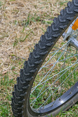 Fragment of a mountain bike tire on a lawn background close-up