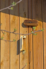 Fragment of a wooden door with a primitive lock close-up