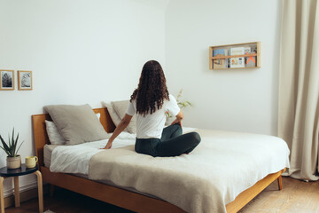 Frau macht Yoga zuhause zur Entspannung auf dem Bett