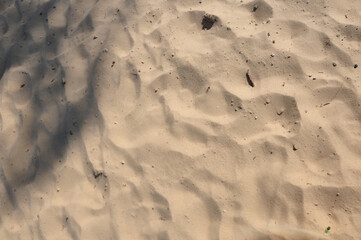 Das Sandbild: weicher weiße Sanstrand, Struktur. Sandstrand mit Fußspuren.
