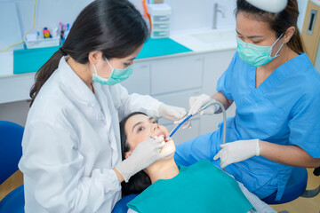 Dental team wearing face mask providing treatment service in clinic.
