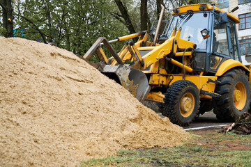 tractor or bulldozer works with a pile of sand for construction