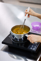 A bright girl cooks sweet dishes at a small production facility