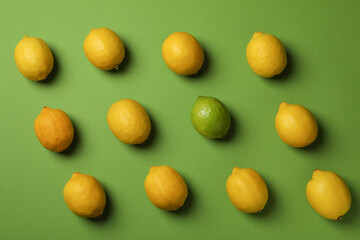 Ripe lemons and lime on green background, top view