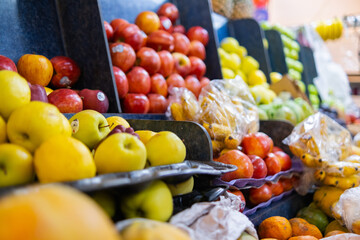 Close-up of colorful fruit stand with apples, small bananas, and more