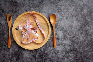 Empty plate with measuring tape, knife and fork