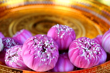 Pink lotus flowers on gold color tray(Thai ancient style) in temple, The lotus flower take out of outer petal in round shape, Thailand.