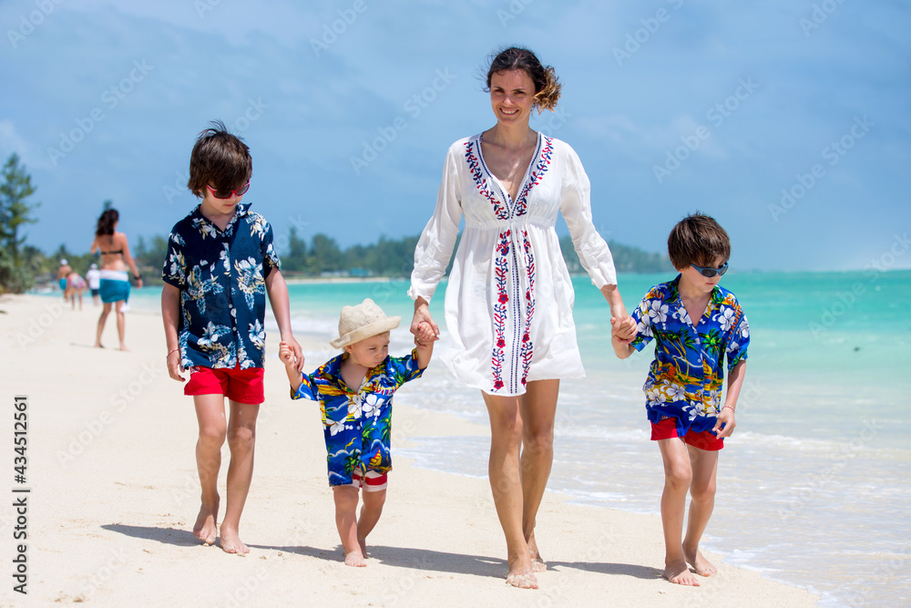 Poster Mother and children playing at tropical beach. Family sea summer vacation. Mom and kids, boys, play in the water. Ocean and water fun for parent and kids. Fit and healthy family