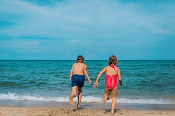 kids run to swim on tropical beach