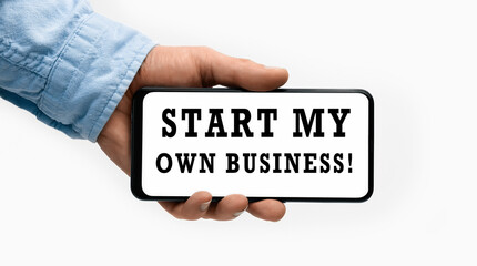 Closeup of a male hand holding Smartphone with horizontal text Start my own Business on display