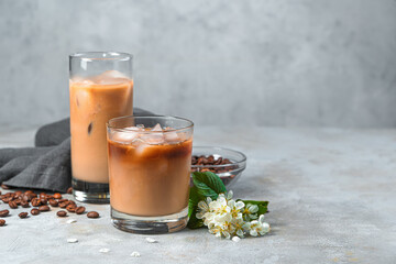 Iced coffee with milk on a gray background with coffee beans.