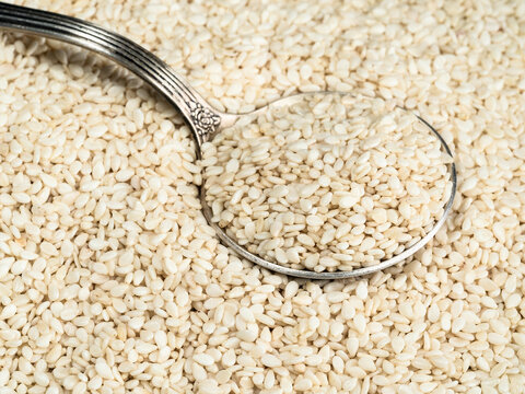 silver tablespoon in white sesame seeds