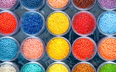 Beads in a box of different colors close up. Top view