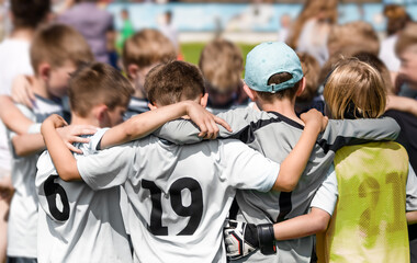 Happy Sporty Team Huddling With Coach. Children Football Team Standing Together in a Circle Before...