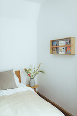 gemütliches Schlafzimmer mit frischen Bluen auf dem Nachtisch