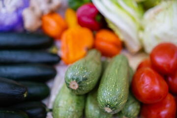 Close-up of colorful vegetable stand with tomatoes, zucchini, and more