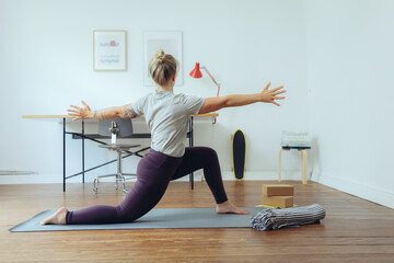 Frau macht Yoga im Homeoffie zur Entspannung und als Ausgleich 