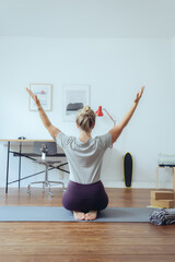 Frau macht Yoga im Homeoffie zur Entspannung und als Ausgleich 