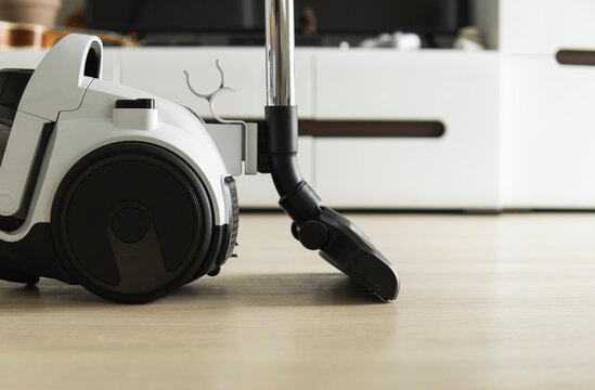 Bagless cyclone vacuum cleaner on a laminate. Electrical apparatus that by  means of suction collects dust and small particles from floors and other  surfaces. Stock Photo | Adobe Stock