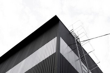 Black and white corrugated iron sheet used as a facade of a warehouse or factory. Texture of a seamless corrugated zinc sheet metal aluminum facade. Architecture. Metal texture.