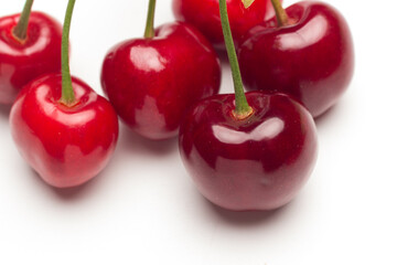 Small red cherries on a white background