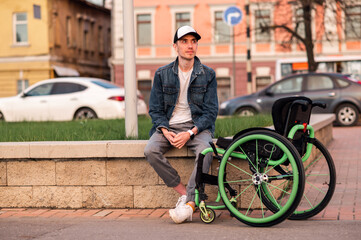 a young man in a disabled person is sitting on a bench next to a wheelchair
