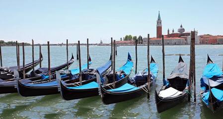 Fototapeta na wymiar gondolas typical Venetian boats moored in the Giudecca canal in front of the church of San Giorgio Saint George in Italy