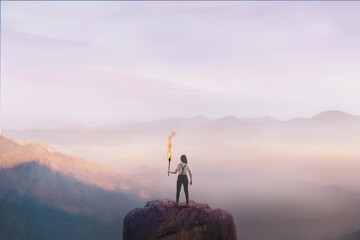 woman on top of a mountain with a torch, concept of success