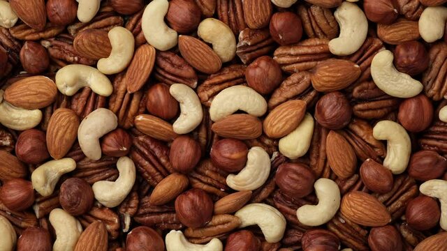 Mix nuts cashews, almonds, hazelnuts top view. Sliding shot. 4K UHD video