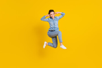 Fototapeta na wymiar Full length body size photo young pretty girl jumping up showing v-sign gesture smiling isolated vivid yellow color background