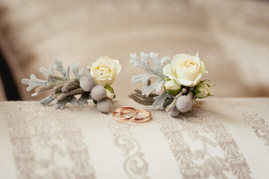 delicate boutonnieres with little white roses and brunei and wedding rings 