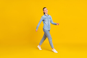Fototapeta na wymiar Full length body size view of attractive cheerful girl wearing cozy clothes walking isolated over bright yellow color background