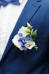 Blue wedding boutonniere on Groom's jacket