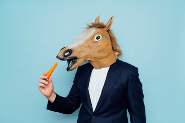 Man with horse mask eating.