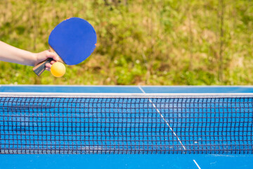 Blue table tennis or ping pong. Outdoor tablet tennis. Close-up ping-pong.  Accessories for table tennis racket and ball on a blue tennis table. Sport.