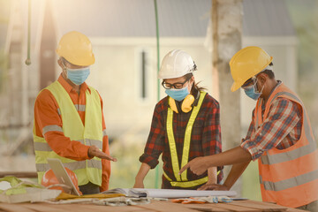 female inspectors and architects discuss with head engineer about construction project.Multi-ethnic group of engineers meeting at construction site in eveing time