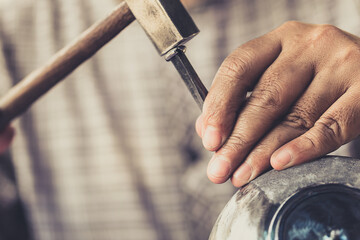 closeup professional male handcraft working hammer engraved on the silver tin bowl masterpiece...