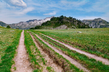 Fototapeta na wymiar Landscape of forests, mountains, white clouds and a path for hikers in Pyrenees of France.