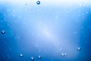 Macro photo of air bubble in water in the glass with blue soft color lighting for background or wallpaper.