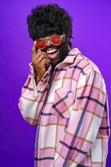 Fashion portrait of african american man in glasses against purple background